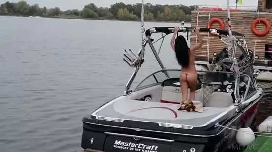 Sexy woman drives boat, playfully interacting with the controls